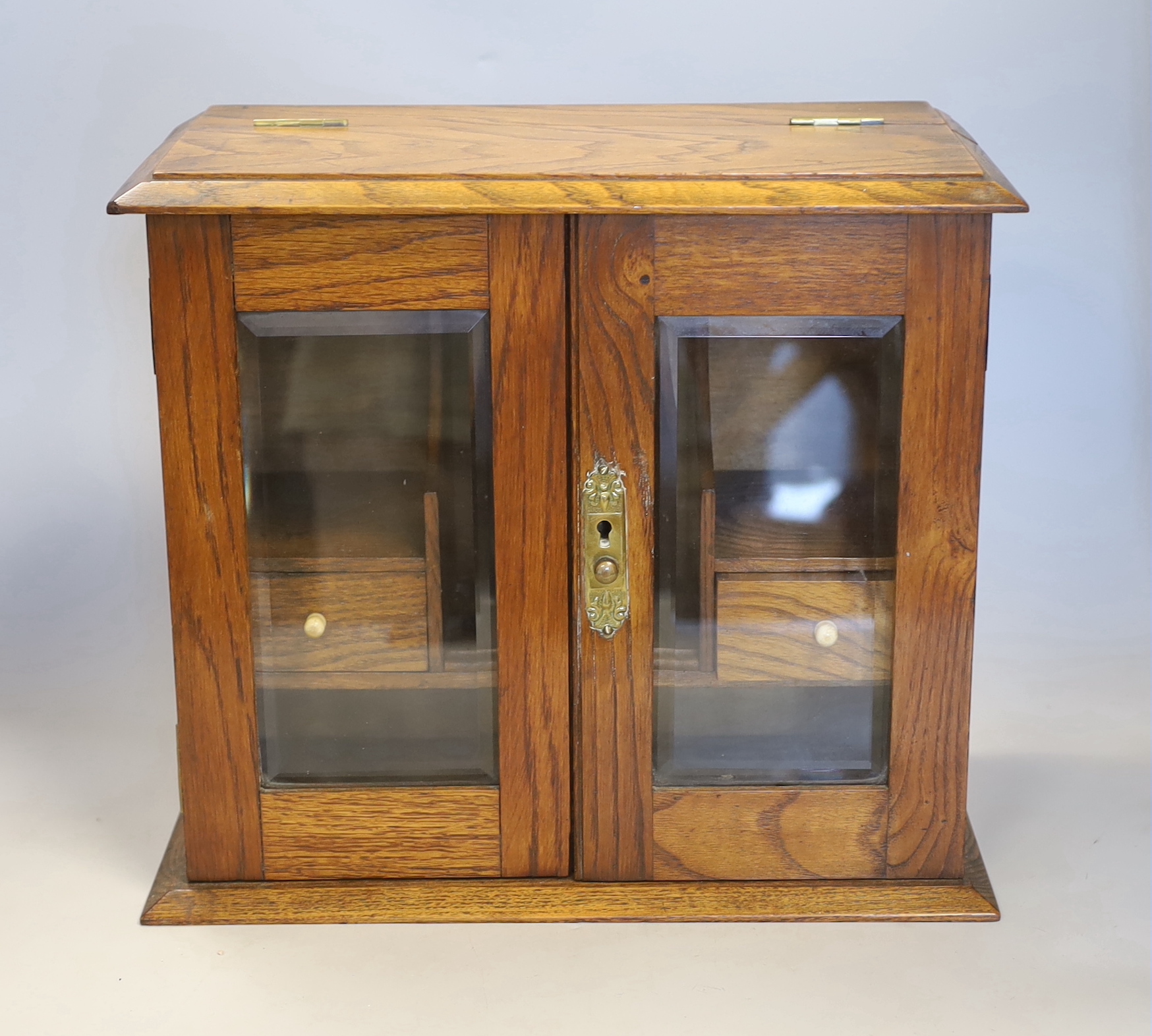 An oak cased smoker’s cabinet with bone handles and brass mounts, 31cm high